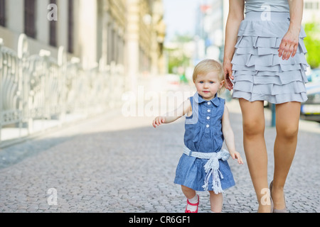 Bambino con la madre a camminare in città Foto Stock