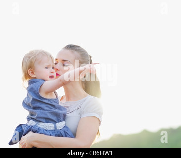 Ritratto di Madre kissing baby puntando su uno spazio di copia Foto Stock