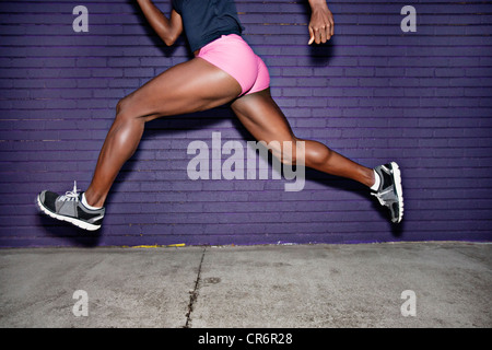 Atleta femminile in esecuzione sul marciapiede Foto Stock