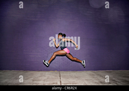 Atleta femminile in esecuzione sul marciapiede Foto Stock