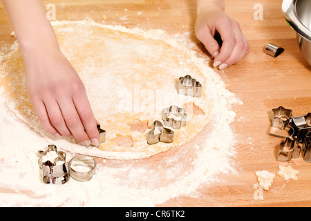 Mani femminili premendo il natale stampi in pasta Foto Stock