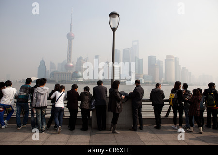 Turisti sul Bund da Puxi guardando attraverso il fiume Hungpu Skyline di Pudong di Shanghai Foto Stock