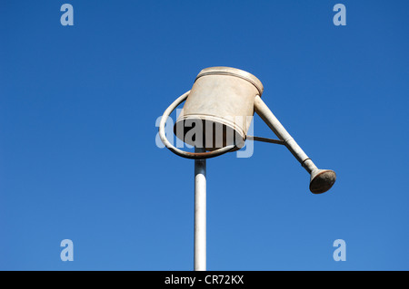 Annaffiatoio capovolto su un palo contro un cielo blu Foto Stock