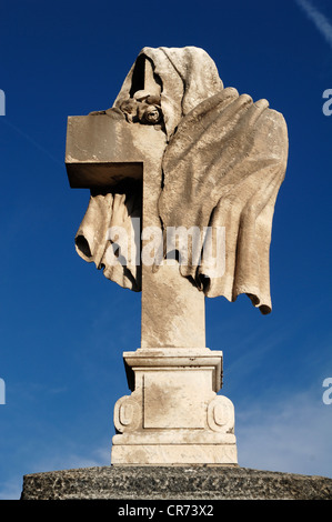 Panno drappeggiato intorno a una croce di pietra del XIX secolo, contro un cielo blu nel cimitero di Guebwiller, Route de Colmar, Guebwiller Foto Stock