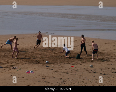 Gruppo di adolescenti che giocano a cricket sulla spiaggia, Cornwall, Regno Unito Foto Stock