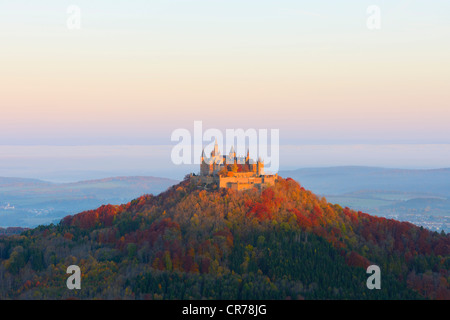 Burg Hohenzollern Castello nella luce del mattino con foresta autunnale, nebbia mattutina, Svevo, Baden-Wuerttemberg Foto Stock