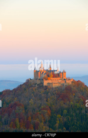 Burg Hohenzollern Castello nella luce del mattino con foresta autunnale, nebbia mattutina, Svevo, Baden-Wuerttemberg Foto Stock