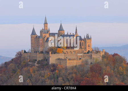 Burg Hohenzollern Castello nella luce del mattino con foresta autunnale, nebbia mattutina, Svevo, Baden-Wuerttemberg Foto Stock
