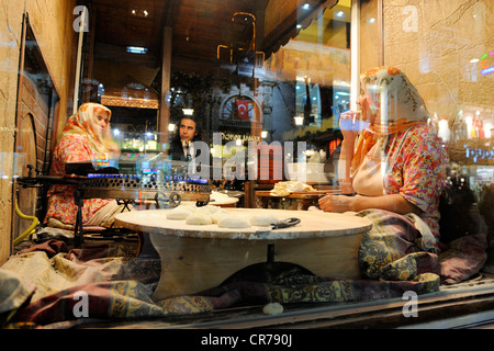 Turchia, Istanbul, Beyloglu, quartiere Taksim, donna che fa il tallone in una finestra del ristorante in Istiklal Caddesi Street Foto Stock