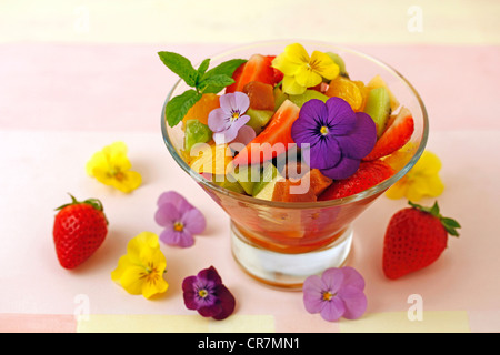 Macedonia di frutta con mela cotogna e petali di fiori. Ricetta disponibile Foto Stock