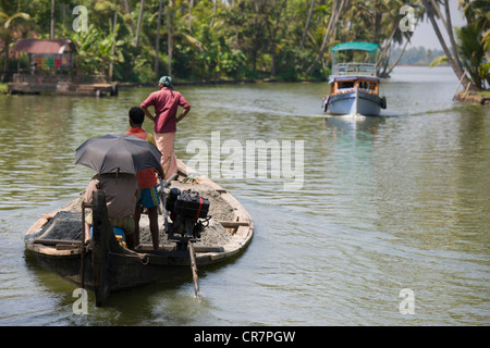 Imbarcazione turistica che si avvicinano ad un sovraccarico includersi in una via navigabile del lago Vattakayal, vicino a Alappuzha (Alleppey), Kerala, India Foto Stock