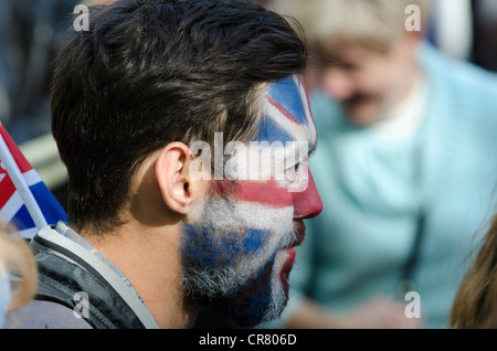 L'uomo con la bandiera dell'Unione faccia dipingere il diamante della regina celebrazioni giubilari di festeggianti in attesa di pop concert in The Mall 4/6/12 Foto Stock