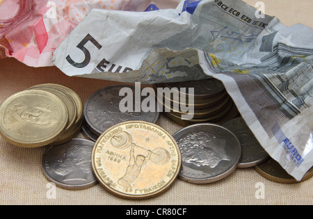 Crumpled le banconote in euro sono messe da parte per fare la strada per un ritorno della dracma greca monete. Foto Stock