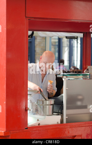 Ice Cream venditore scoop mette in cono Covent Garden, Westminster, London Regno Unito Foto Stock