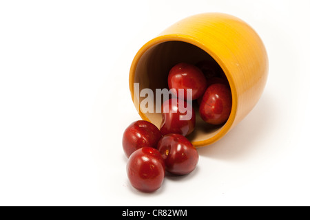 Succosa rosso rubino le ciliegie in una tazza di colore arancione Foto Stock