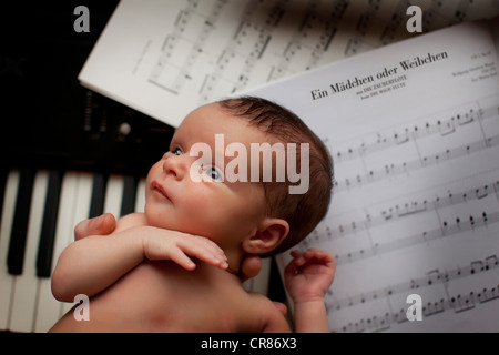 Neonato, due settimane, pianoforte, foglio di musica Foto Stock