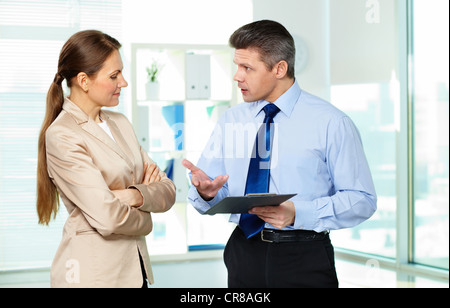 Formalmente vestiti i giovani a discutere di documenti di office Foto Stock