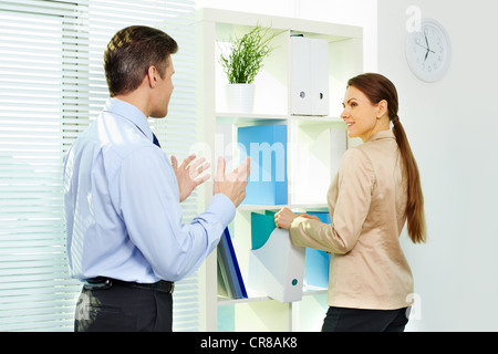 Formalmente vestiti giovani interagire in office Foto Stock