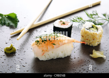 Un assortimento di sushi con zenzero e wasabi su di una superficie di pietra Foto Stock