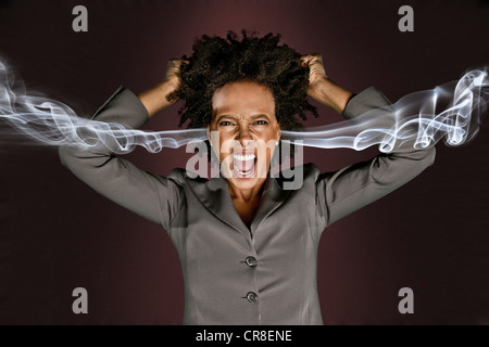 Frustrati donna con fumo proveniente dalle orecchie Foto Stock