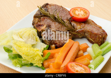 Due costolette di agnello grigliate con verdure al vapore. Foto Stock