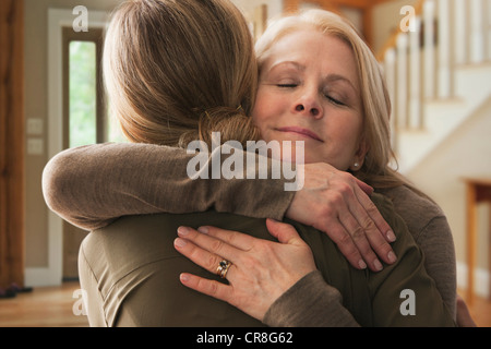 Madre abbracciando figlia adulta Foto Stock