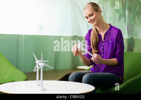 Giovane donna che guarda al modello della turbina eolica Foto Stock