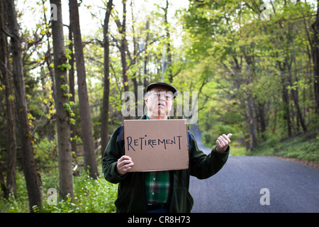 Senior man Holding firmano in foresta, ritratto Foto Stock