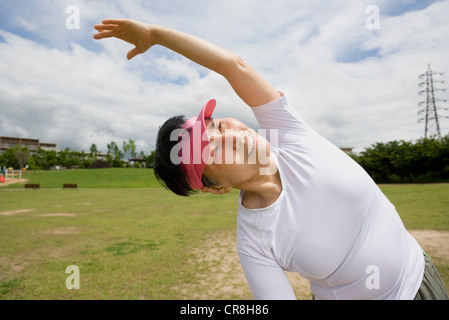 Senior donna stretching in un parco Foto Stock