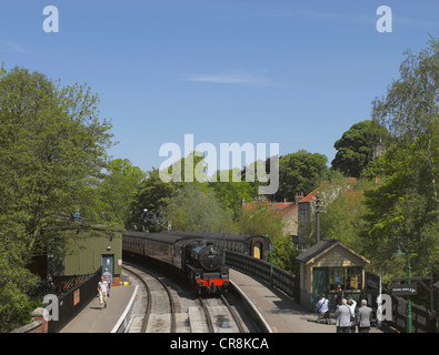 Treno locomotiva a vapore in arrivo alla piattaforma della stazione ferroviaria di Pickering in estate North Yorkshire Inghilterra Regno Unito Gran Bretagna Foto Stock