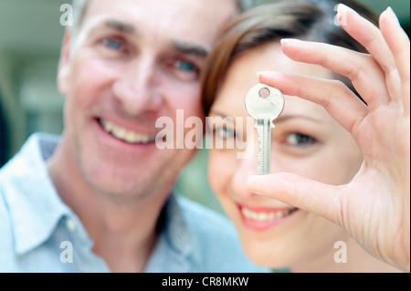 Donna che mantiene chiave di casa, l'uomo in background Foto Stock