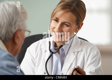 Medico prendere senior mans pressione sanguigna, close up Foto Stock