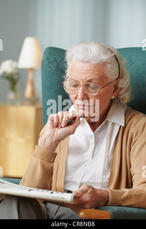 Senior donna facendo il cruciverba Foto Stock