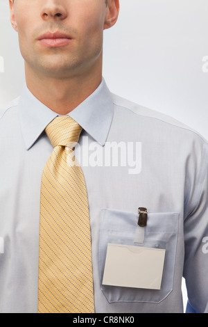 Giovane uomo che indossa cravatta e il nome distintivo Foto Stock