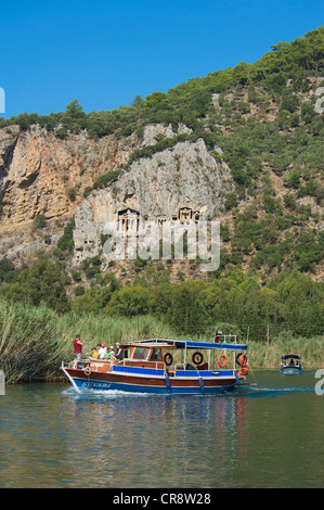 Imbarcazioni per escursioni sul fiume Dalyan nella parte anteriore della roccia tombe di Caunos o Kaunos vicino a Marmaris, Costa Turca dell'Egeo, Turchia Foto Stock