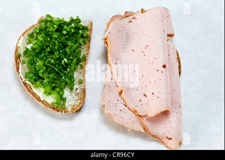 Una fetta di pane con erba cipollina e una fetta di pane con una fetta di pagnotta di carne Foto Stock