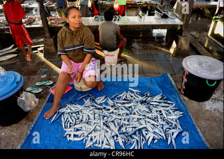 Venditore di pesce al mercato del pesce in Kota Biak offrendo pesce appena pescato, isola di Biak, Papua occidentale, in Indonesia, sud-est asiatico Foto Stock