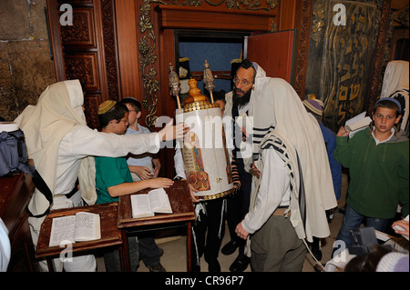 Bar Mitzvar, ebraiche provenienti di età rituale, la Torah di scorrimento è tornato alla Torah cabinet, la sua schiena appoggiata al Foto Stock