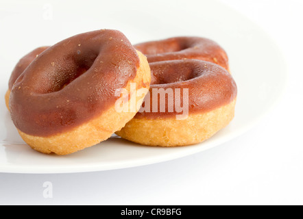Ciambelle al cioccolato su una piastra bianca Foto Stock