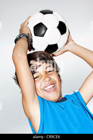 Happy jumping boy, cute kid giocando a calcio, bambino attivo, giovane maschio teen portiere godendo di gioco di sport, cattura la sfera Foto Stock