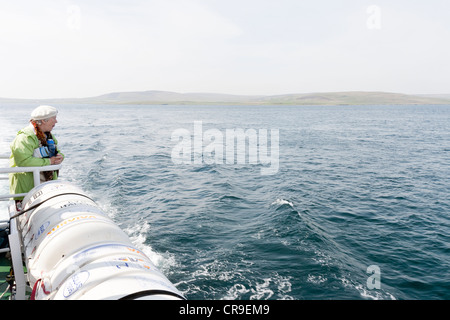Il Tingwall Rousay traghetti Orkney Isles, Scozia. Un anziano turista femminile che guarda al mare Foto Stock
