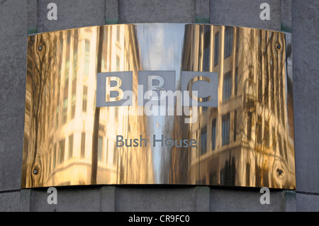 Ottone nome BBC piatto & riflessioni sulla superficie curva al di fuori del Bush House quartier generale per la BBC World Service Aldwych Londra Inghilterra REGNO UNITO Foto Stock