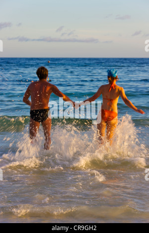 Un paio in esecuzione nell'acqua sulla spiaggia, Isola di Bohol, Filippine Foto Stock