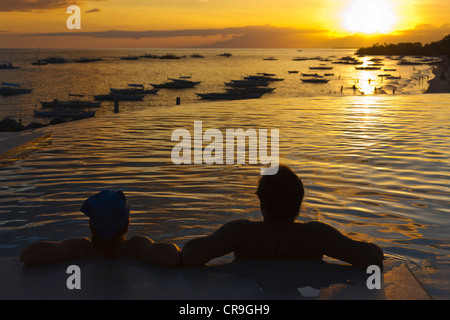 Turista giovane guardare il tramonto sulla spiaggia, Isola di Bohol, Filippine Foto Stock