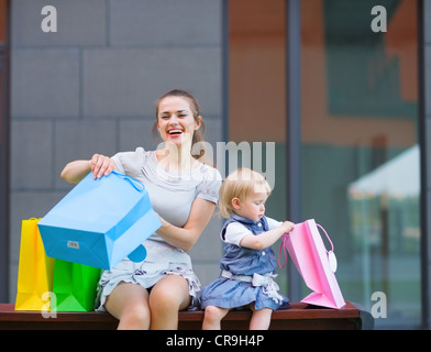 La madre e il bambino esamina gli acquisti dopo lo shopping