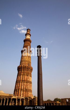 La Qutub Minar, India del più alto minareto in mattoni e la colonna di ferro contro un cielo blu, Delhi, India. Foto Stock