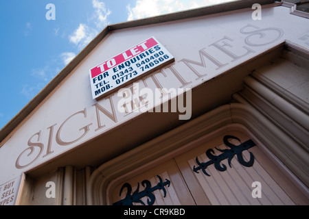 Esterno della chiesa convertito girata negozio chiamato segno dei tempi con un lasciare bordo sopra il nome del negozio Foto Stock