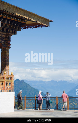 I turisti in corrispondenza del sito di 108 chortens costruito nel 2005 per commemorare la battaglia con militanti, Dochu La pass (3140m), Bhutan, Asia Foto Stock