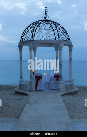 Questo è un gazebo di nozze cena a lume di candela setup sulla spiaggia per una romantica cena per qualsiasi coppia al tramonto. Foto Stock