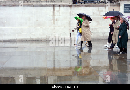 La gente ha superato una parete piana sotto la pioggia Foto Stock